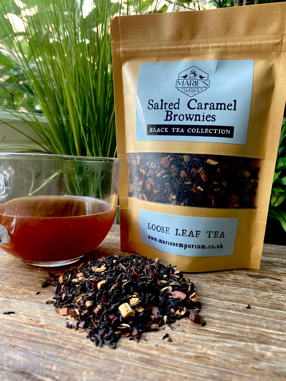 Loose leaf tea package with a glass of tea on a wooden surface, featuring 'Marie's Emporium' branding.