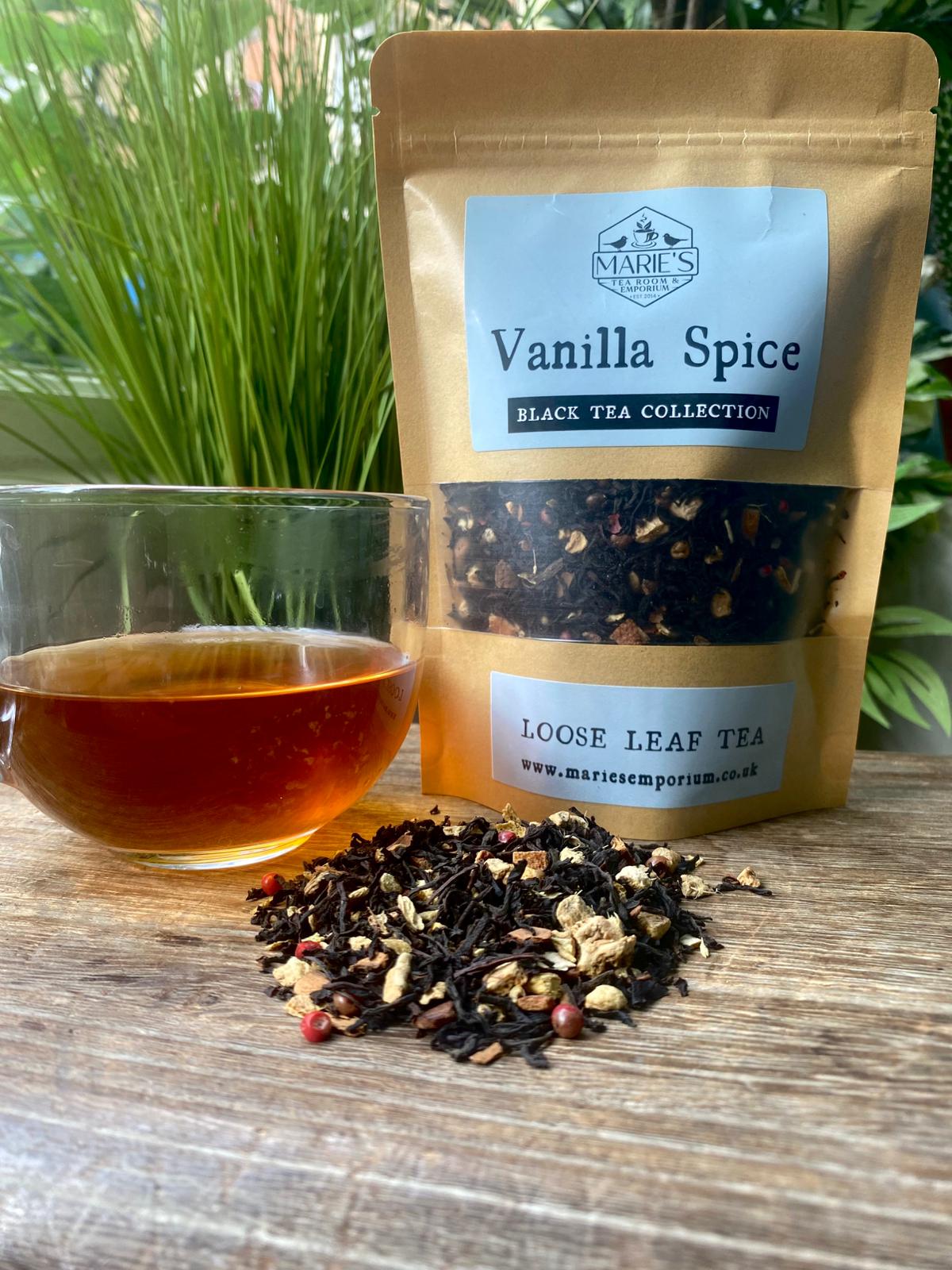 Vanilla Spice maries loose leaf tea package with a glass of tea on a wooden surface